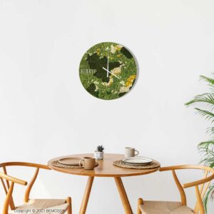 stôl s rastlinou a hodinami na stene nad ňou, ktoré hovoria machovy obraz, stabilizovany mach, machová stena, machová dekorácia